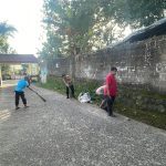 Bhabinkamtibmas Polsek CWI Polres Bogor gotong royong bersama warga Desa Banjarwangi memberaihkan jalan lingkungan